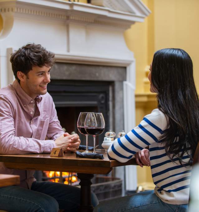 A couple enjoying a glass of wine at a dinner table