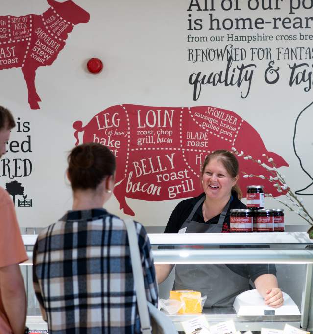 Uncle Henry's farm shop meat counter with two people speaking to a server over the counter.