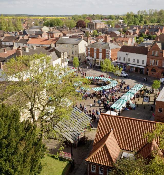 an aerial view of Market Rasen market with stalls and trees in foreground