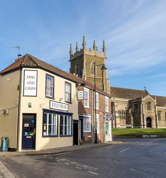 A church and fish and chip shop street under blue skies
