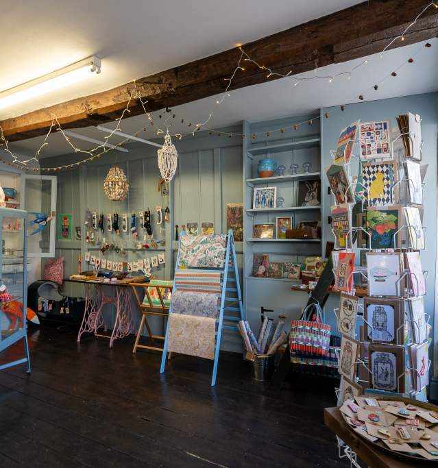 an independent gift shop with products around the room and wooden beam across the ceiling