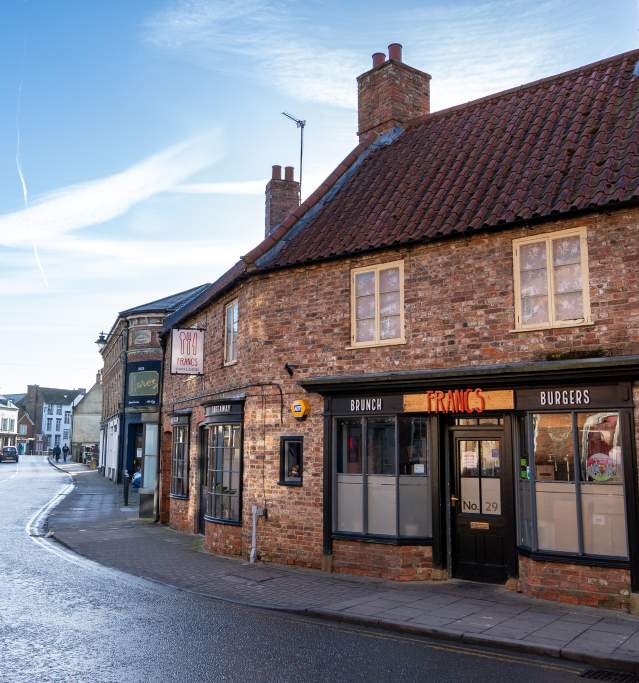 a street in horncastle with historic houses and restaurant in the foreground