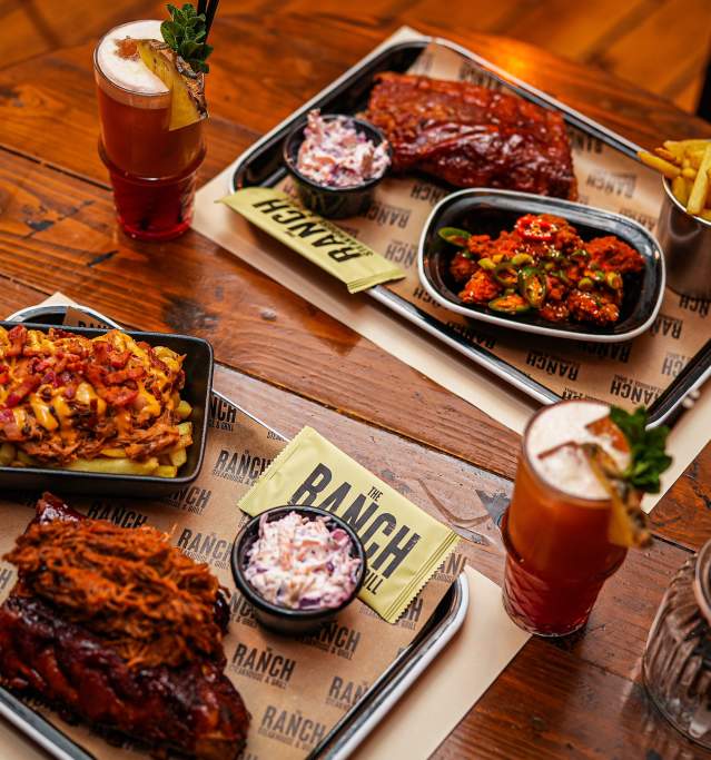 a table with barbeque meals and drinks