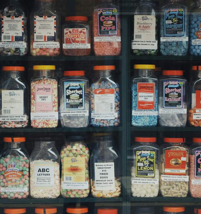 a shelf in a sweet shop with tubs of sweets