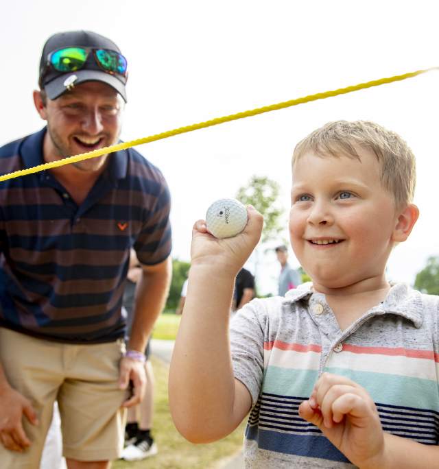 A child smiles with a golf ball at the U.S. Senior Open at Saucon Valley