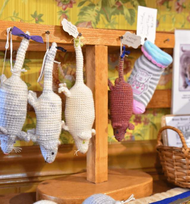 Four knitted mice hanging from pins