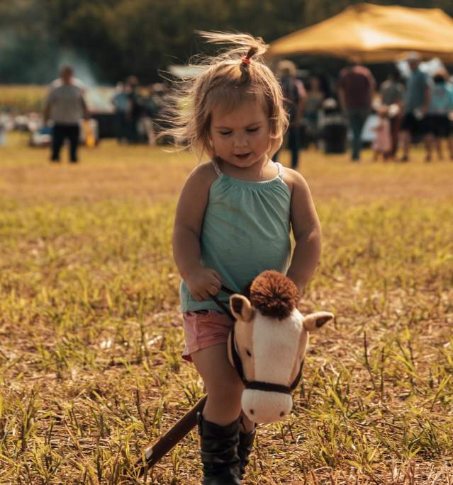 Young girl riding toy horse