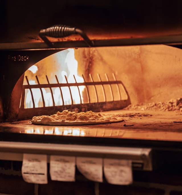 Pizza going into wood fire oven
