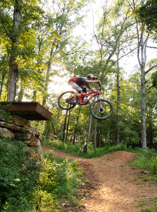 A man jumping off a large bike feature