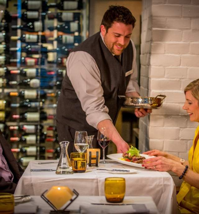 Dinner being served by waiter for the couple dining
