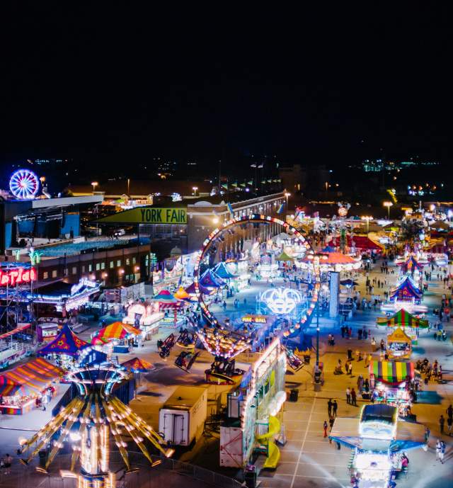 Aerial view of York State Fair at night with glowing rides