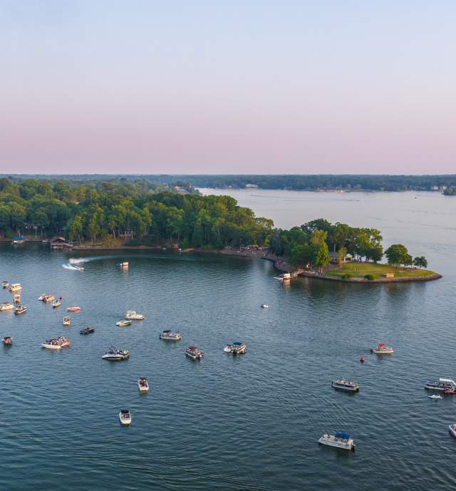 Lake with many boats on it with a piece of land seen