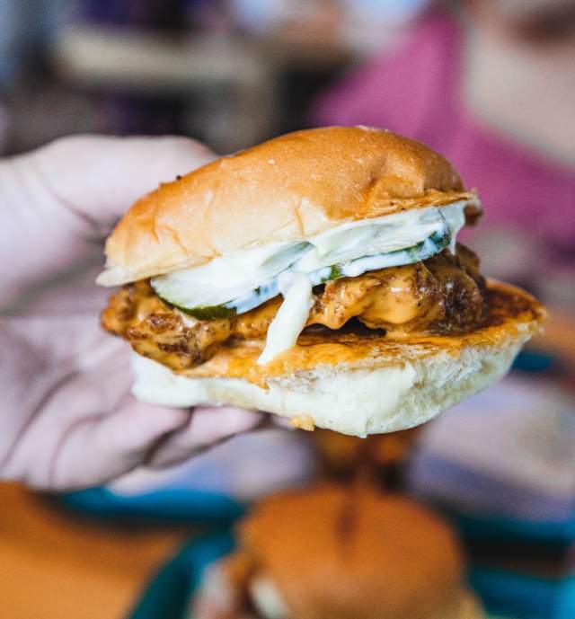 Mans hand holding a burger