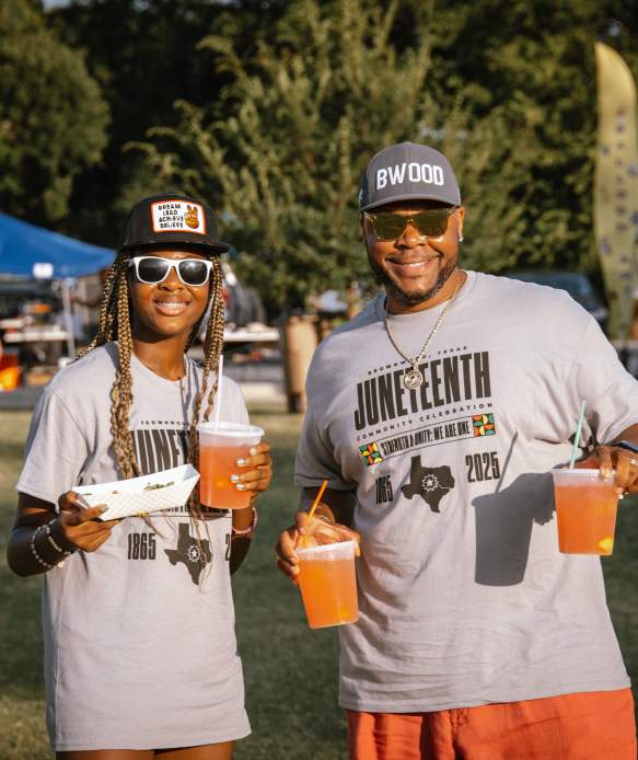 Photo of two people with drinks and food from vendors at the Fun in the Park event during the Juneteenth celebration.
