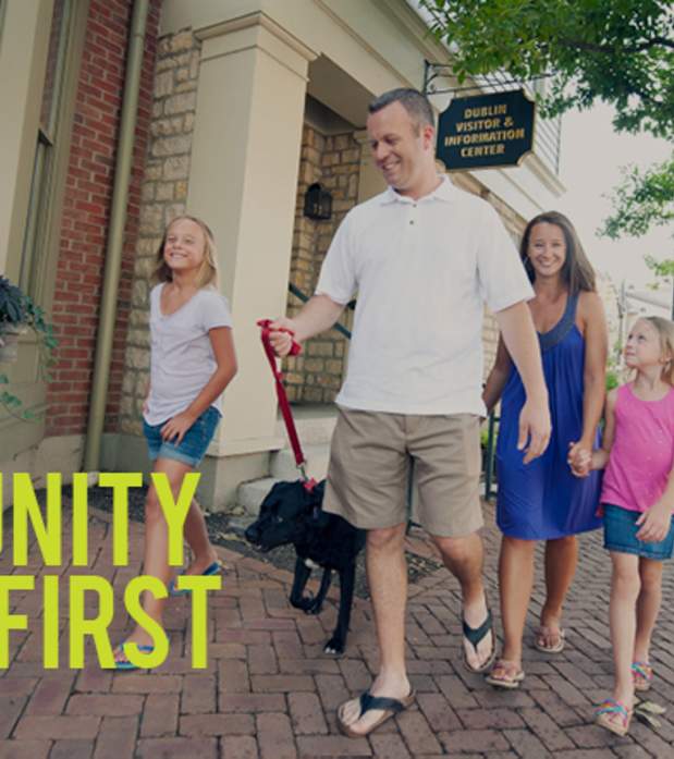 Family of four walking down the brick streets in Historic with their dog.