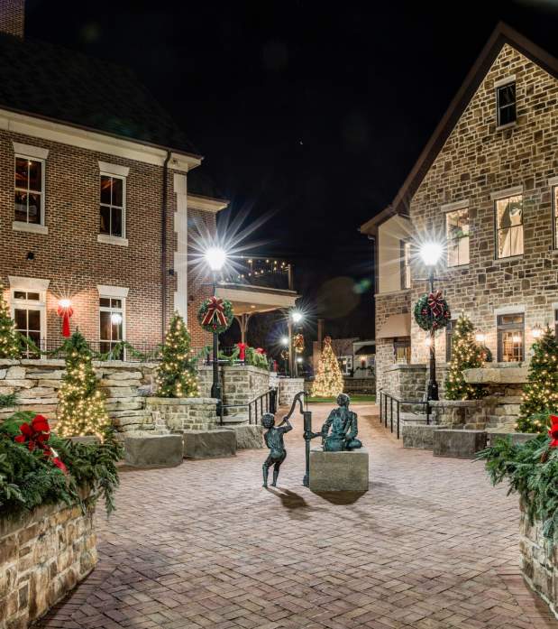 The view of a Downtown Dublin corner decorated with trees and lights for the holidays at night.