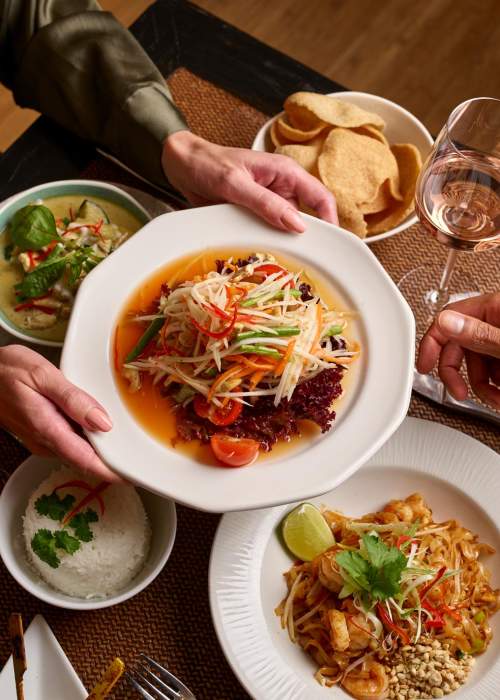 Careys Manor Food at The Zen Garden - plates of thai food being handed over table