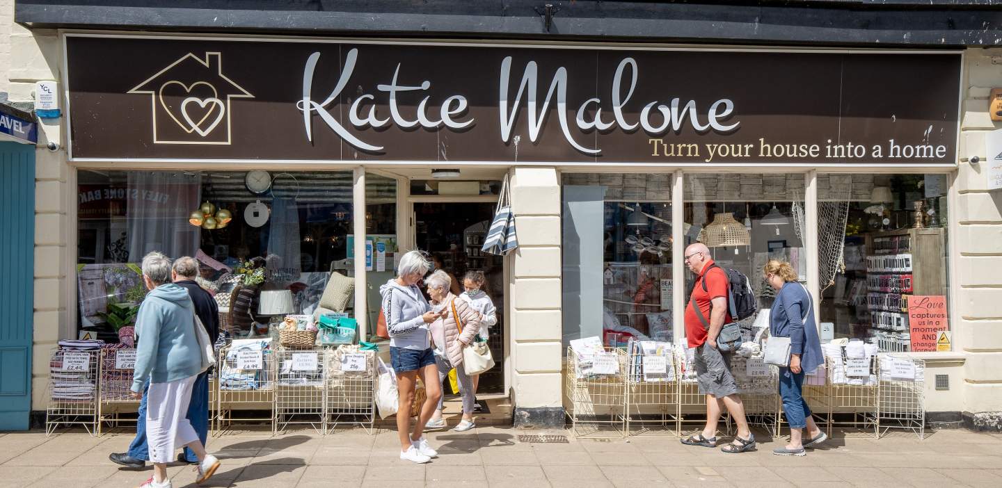 shoppers outside a homeware store titled "Katie Malone: turn your house into a home"