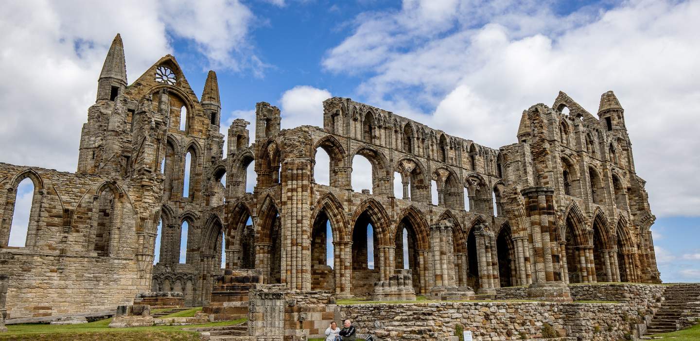 An image of Whitby Abbey under a blue sky