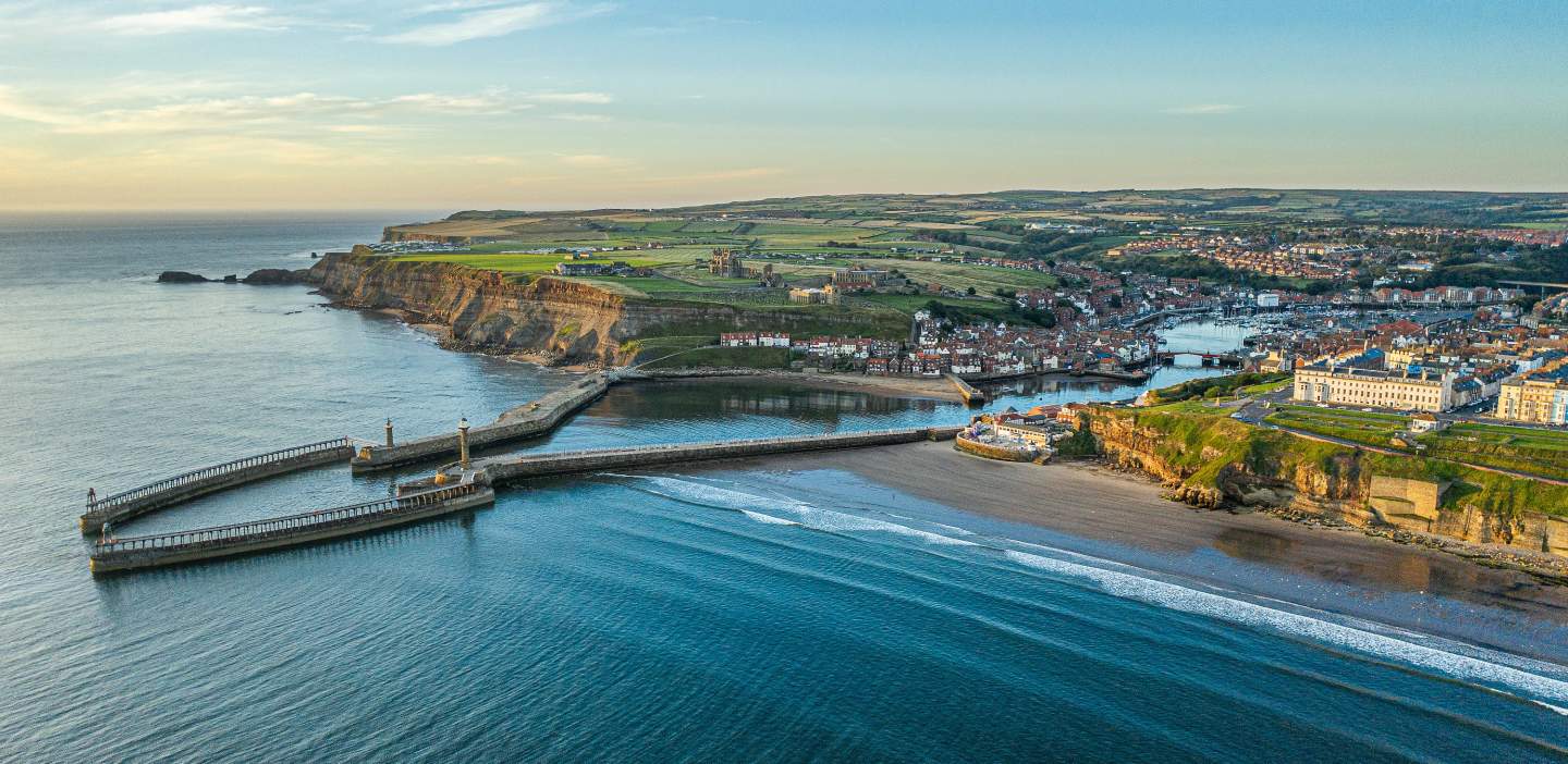A drone image of Whitby from the sea looking back on the pier and the town