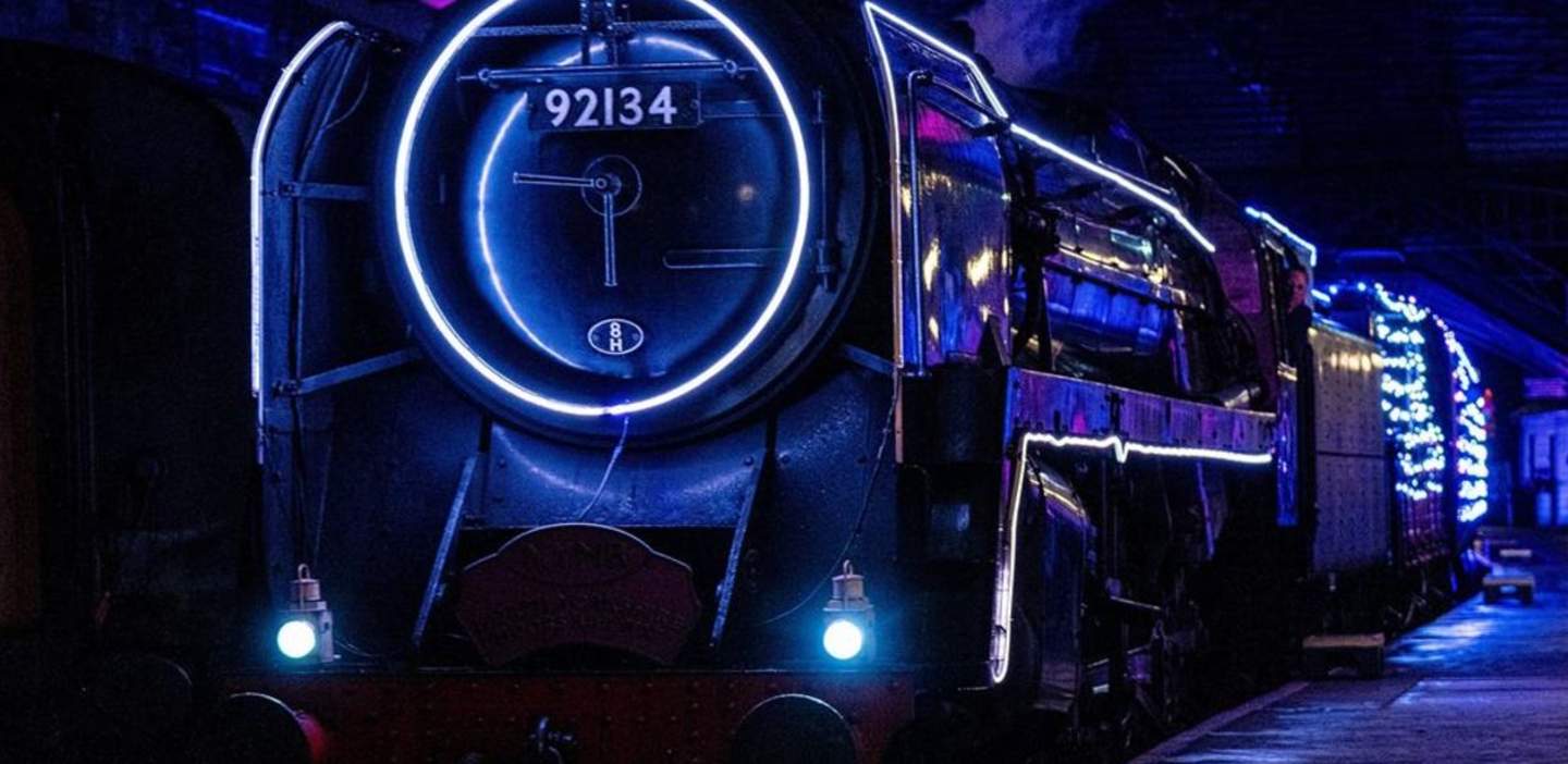 Tron-like image of a vintage train at night covered in sci-fi blue LED strips