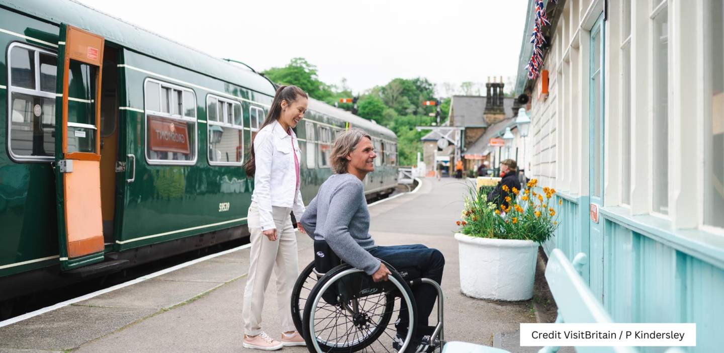 An image of a man in a wheelchair and a woman at the North Yorkshire Moors Railway