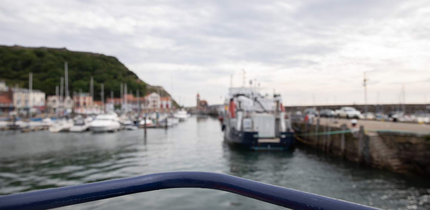 Out of focus shot from the prow of a boat looking out across a busy harbour on the north yorkshire coast