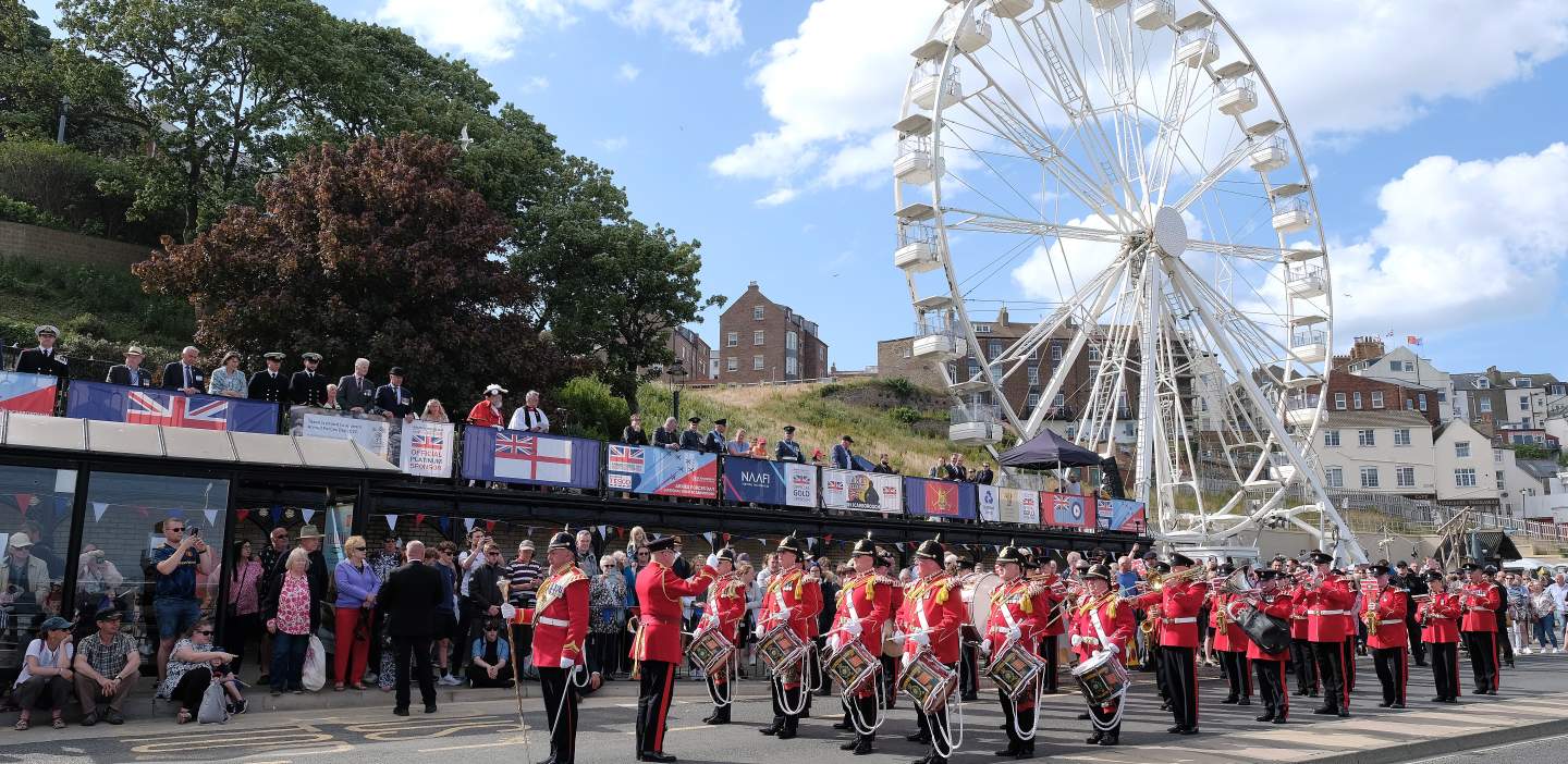 Military marching in front of the wheel on Scarborough south bay