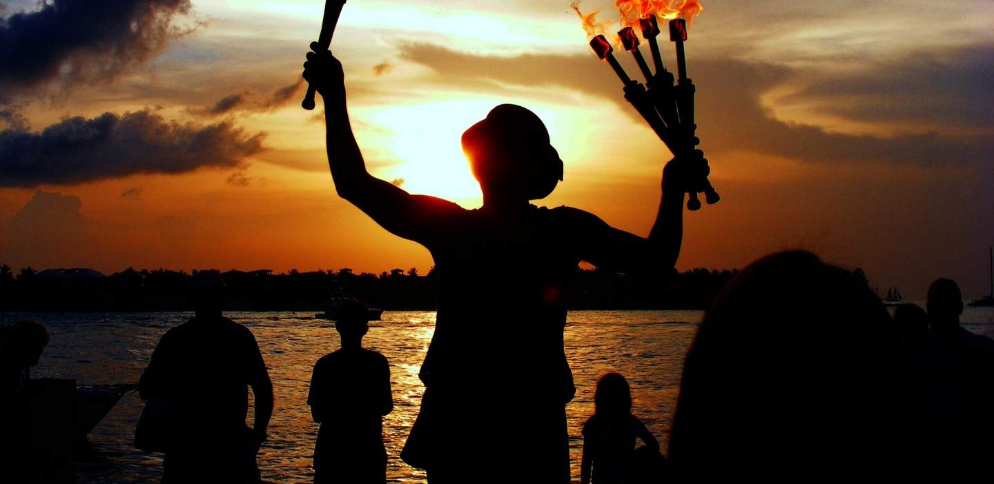 Flamethrowing juggler at sunset by the sea