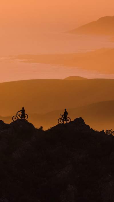 Silhouettes of mountain bikers at Cerro Alto at dusk