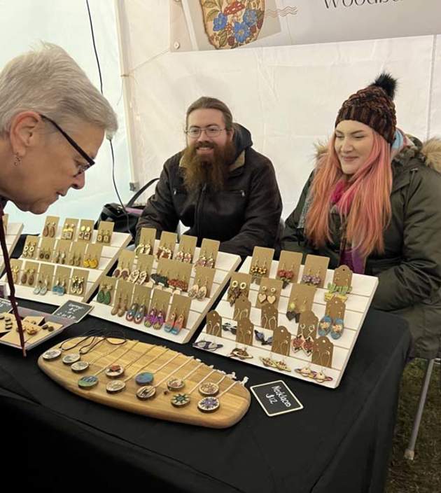 A women looking at hand crafted ornaments on a display table at ChristkindlMarkt at Dill's Tavern in Dillsburg