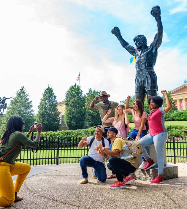 group of people posing for photo a Rocky Statue