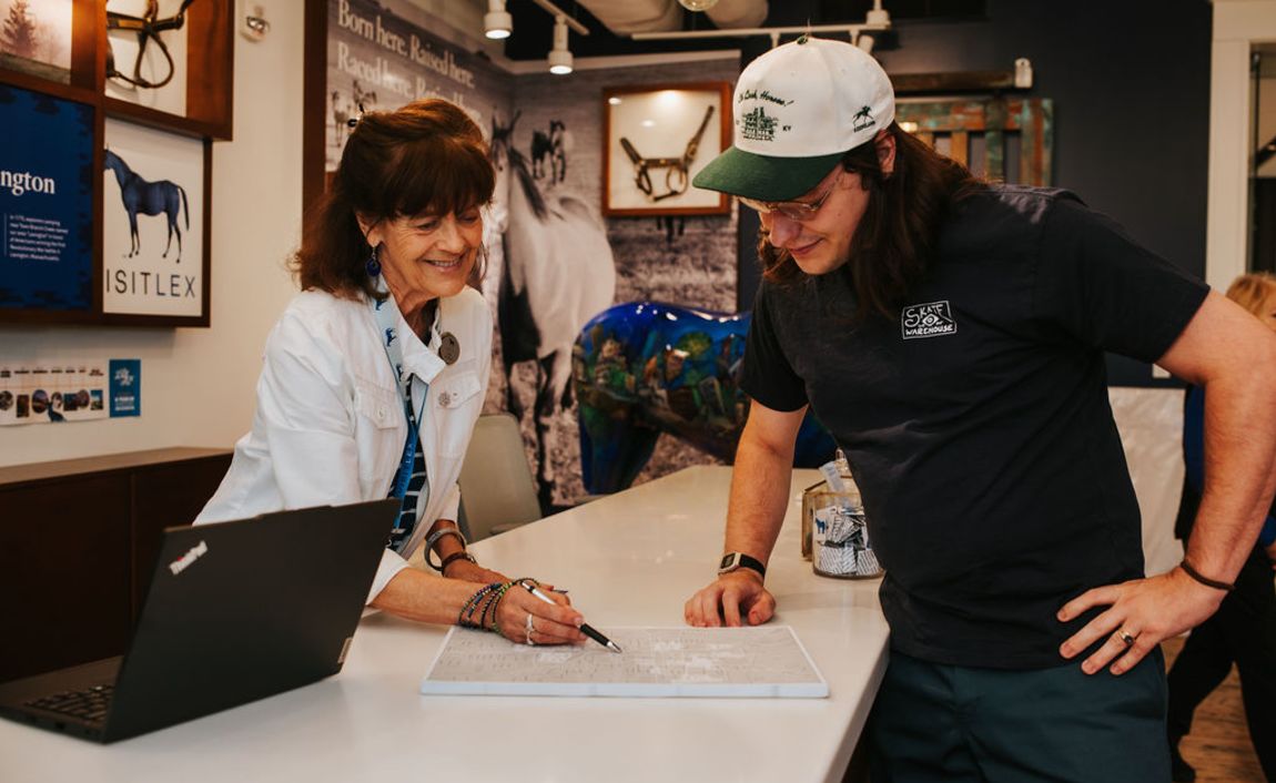 A visitor information specialist assisting a visitor at the counter