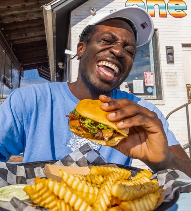 Person Eating a Burger at Al's Burger Shack in Chapel Hill