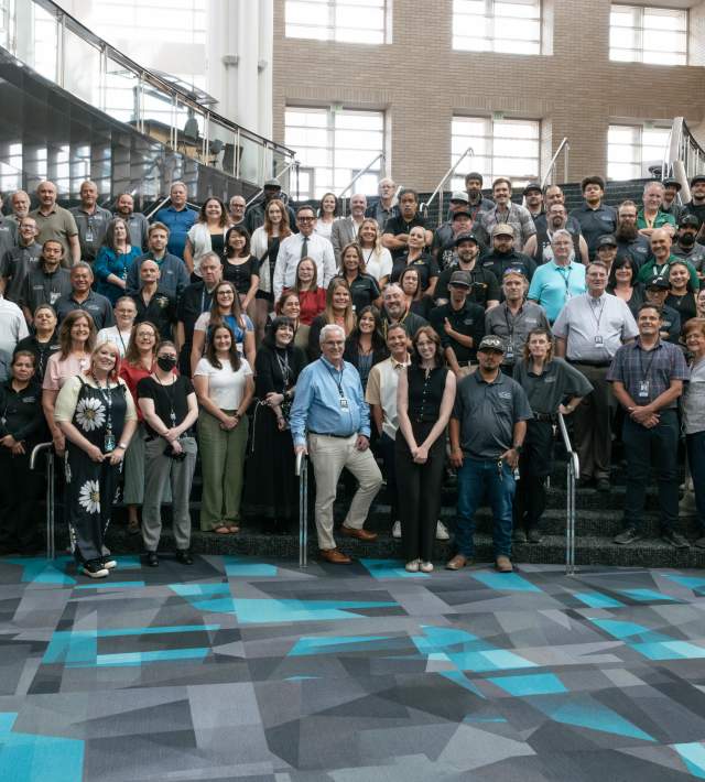 Photo of the Salt Palace Convention Center and Mountain America Expo Center all staff photo on staircase inside the Salt Palace Convention Center.