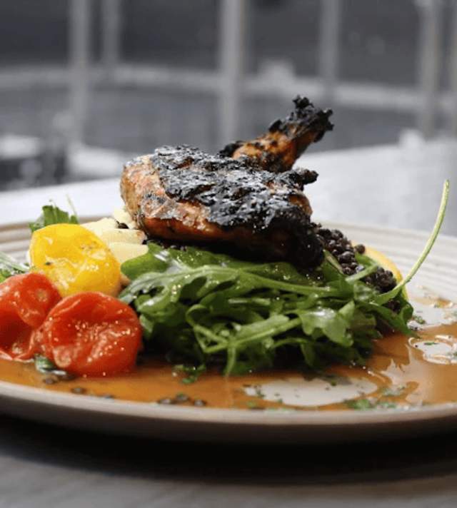 PickleDilly's at APEX Pickleball blackened chicken on a bed of arugula topped with tomatoes