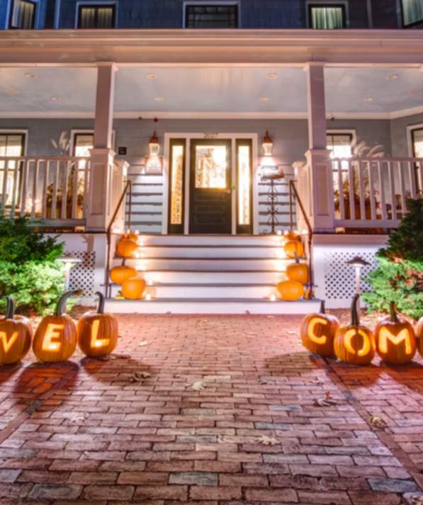 The Inn at Hastings decorated with pumpkins lit up along the front walkway.