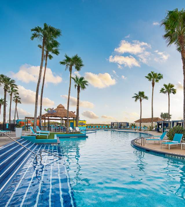 Clear blue pool with tropical setting facing the beach
