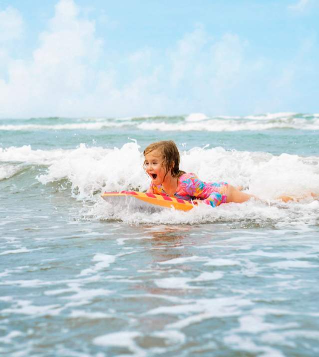 Little Girl Board Surfing at the Beach