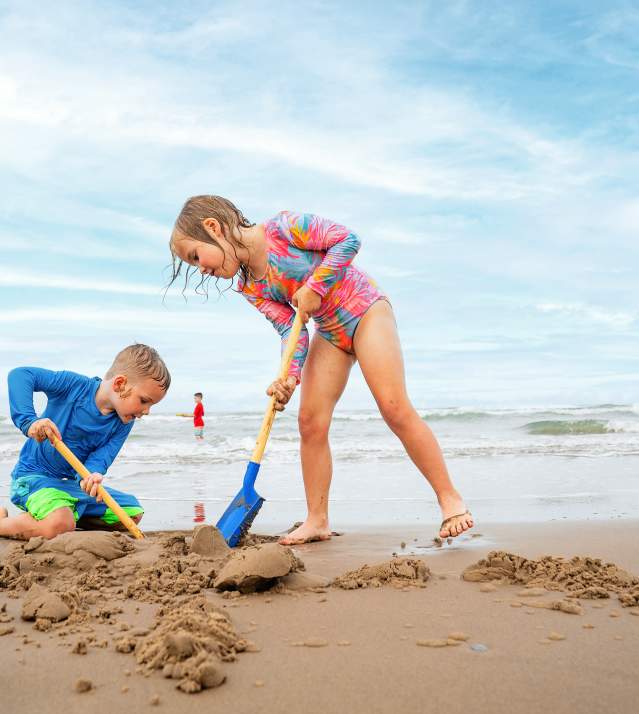 Kids digging a whole on the beach