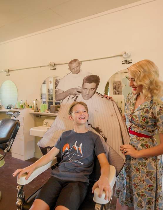 A child sits in the Elvis chair at the Chaffee Barbershop Museum, Fort Smith, Arkansas.