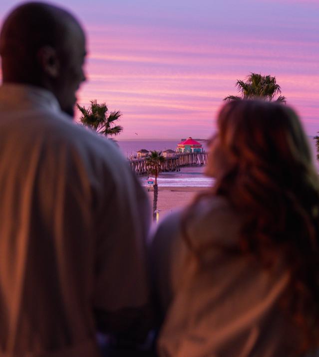 Couple on the balcony at sunrise Huntington Beach in Kimpton Shorebreak Resort