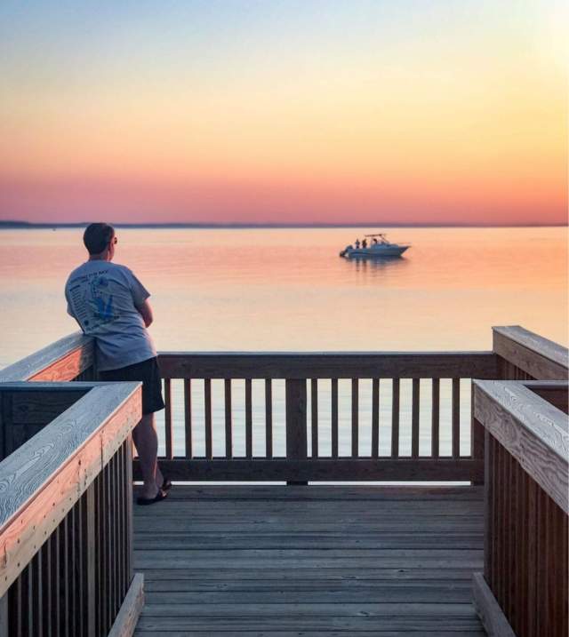 Man observing sunset from pier