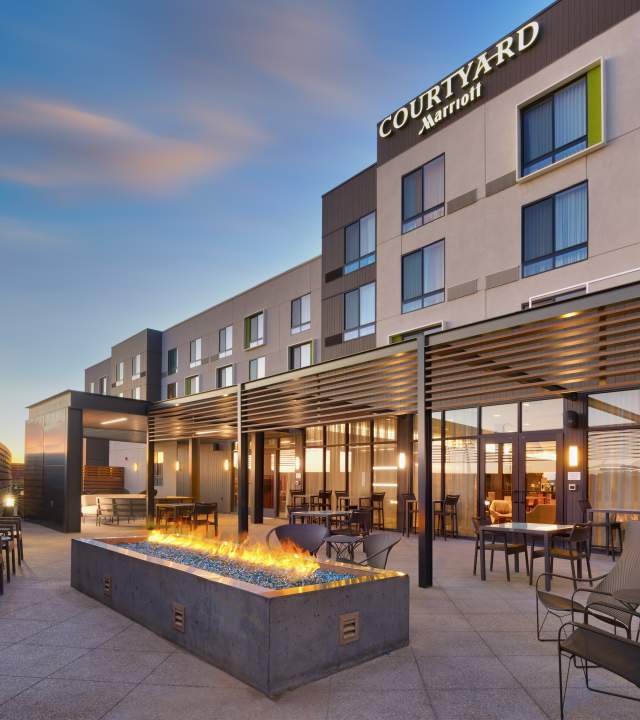 A group space on the patio at the Courtyard by Marriot in Cedar City with chairs and fireplace