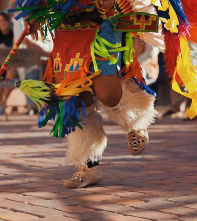 An indigenous Paiture dancer dances in vibrant regalia.