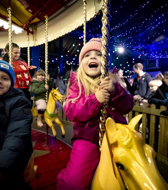 a girl on a carousel at Santa's Winter Wonderland