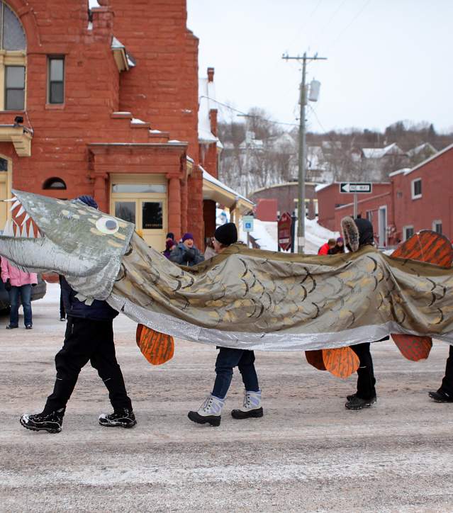 Parade-goers dressed as Väinämöinen walk in Heikinpaiva parade.