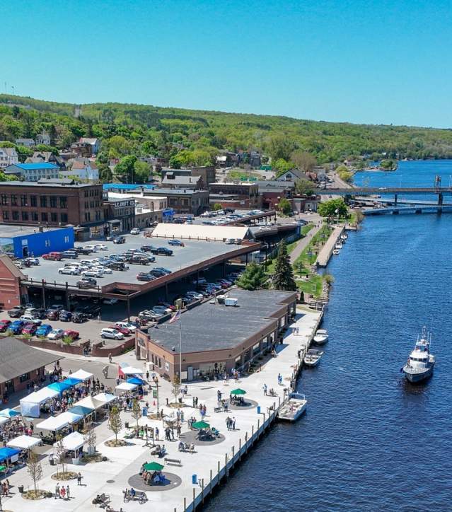 aerial shot of downtown houghton busy with events, boats in the water, and the portage lake lift bridge