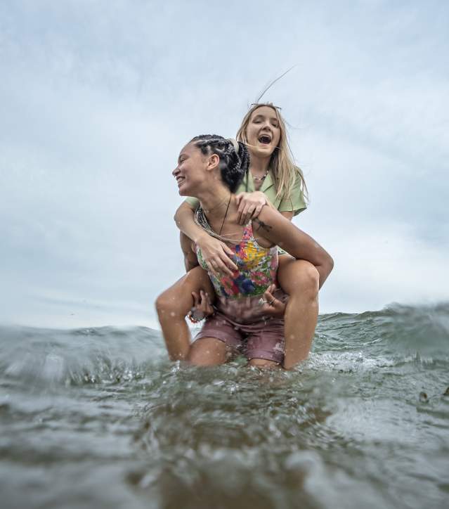 two laughing figures embrace in the water