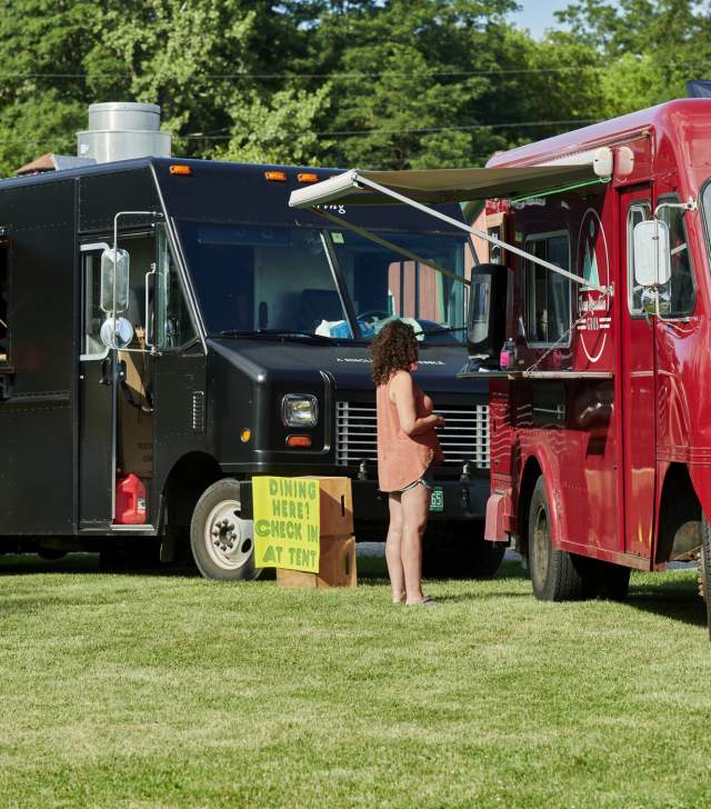 Food Trucks in a grass field serving delicious food made in Vermont